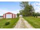 The charming home is shown with a red and white barn near a long driveway at 4605 S 150 W, Columbus, IN 47201