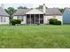 Backyard featuring a screened porch, trimmed bushes, and green grass at 540 Cahill Ln, Indianapolis, IN 46214
