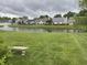 Scenic backyard view of a tranquil pond surrounded by lush greenery and neighboring homes at 540 Cahill Ln, Indianapolis, IN 46214