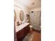 Functional bathroom with a double sink vanity, decorative seashell shower curtain, and wood-look flooring at 540 Cahill Ln, Indianapolis, IN 46214