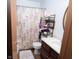 Bathroom featuring a vanity, mirror, shelving unit with towels, and a shower with patterned curtain at 540 Cahill Ln, Indianapolis, IN 46214