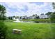 Scenic view of a community pond with fountain, lush lawn, bench, and well-maintained homes in the background at 540 Cahill Ln, Indianapolis, IN 46214