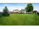 Large, fenced backyard with well-maintained lawn and mature trees, perfect for outdoor activities at 5576 W Glenview Dr, McCordsville, IN 46055