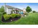 Landscaped backyard featuring a patio with outdoor seating and lush greenery at 5576 W Glenview Dr, McCordsville, IN 46055