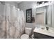 Compact bathroom features patterned shower curtain, vanity with sink, and decorative mirror at 5576 W Glenview Dr, McCordsville, IN 46055