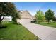 A well-kept one story brick home with lush green lawn, mature trees, and a spacious driveway leading to the garage at 5576 W Glenview Dr, McCordsville, IN 46055