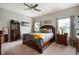 Serene bedroom retreat with neutral tones, plush carpet, and a ceiling fan, offering a relaxing and comfortable space at 5576 W Glenview Dr, McCordsville, IN 46055