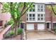 Charming brick townhouse with attached garages, surrounded by mature trees and landscaping at 558 E Vermont St, Indianapolis, IN 46202