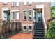 Brick townhouse featuring a brick patio and stairs to a second level entrance at 558 E Vermont St, Indianapolis, IN 46202