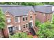A rear view of brick townhomes with private outdoor stairways and a view of the surrounding lush greenery at 558 E Vermont St, Indianapolis, IN 46202