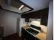 Kitchen featuring dark cabinets, wood countertops, and white appliances at 5711 Bradston Way, Indianapolis, IN 46237