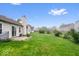 Expansive backyard featuring a patio, green lawn, and fenced perimeter at 6011 Twyckenham Dr, Indianapolis, IN 46236