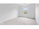 Bright, carpeted bedroom with a view from its single window at 6011 Twyckenham Dr, Indianapolis, IN 46236
