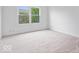Carpeted bedroom with a large window overlooking the backyard at 6011 Twyckenham Dr, Indianapolis, IN 46236