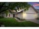 Charming single-story home featuring a two-car garage, well-kept lawn, and tasteful landscaping at sunset at 6011 Twyckenham Dr, Indianapolis, IN 46236