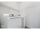 Clean laundry room with a washer, dryer, shelving, and coat hooks at 6011 Twyckenham Dr, Indianapolis, IN 46236