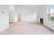 Spacious living room featuring neutral carpet, a cozy fireplace, and two entryways at 6011 Twyckenham Dr, Indianapolis, IN 46236