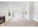 Bright living room featuring vaulted ceilings, neutral carpet, a cozy fireplace, and natural light at 6011 Twyckenham Dr, Indianapolis, IN 46236