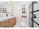 Modern bathroom features stylish vanity, sleek fixtures, and black framed glass shower at 611 N Park Ave # 108, Indianapolis, IN 46204