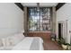 Inviting bedroom featuring a huge window, exposed brick, and a comfortable bed at 611 N Park Ave # 108, Indianapolis, IN 46204