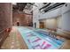 Indoor pool and jacuzzi with exposed brick and tall ceilings, providing a unique recreational space at 611 N Park Ave # 108, Indianapolis, IN 46204