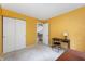 Bedroom with yellow walls, closet, desk, and neutral carpet at 6263 Behner Way, Indianapolis, IN 46250