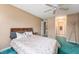 Main bedroom with ceiling fan, queen bed, and teal carpet at 6263 Behner Way, Indianapolis, IN 46250