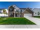 Beautiful two-story home featuring manicured lawn, gray brick, and a welcoming front porch at 628 Tess Blvd, Westfield, IN 46074