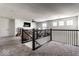 Spacious loft area with a black metal railing, TV, and carpeted floors at 628 Tess Blvd, Westfield, IN 46074