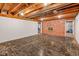 Spacious basement with exposed wood ceiling and brick accent wall with a fireplace at 650 W Main St, Carmel, IN 46032