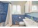 Cozy bathroom with colorful mosaic tile, white fixtures, and a window providing natural light at 650 W Main St, Carmel, IN 46032