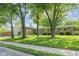 Charming single-story home with stone accents, lush lawn, mature trees, and a pop of color at the front door at 650 W Main St, Carmel, IN 46032