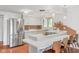 Well-lit kitchen featuring stainless steel appliances, white cabinets, breakfast bar, and tile backsplash at 650 W Main St, Carmel, IN 46032