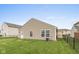 A fenced backyard with a lawn and the exterior of a tan home at 671 Greenway St, Greenwood, IN 46143