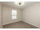 A carpeted bedroom with a large window and a modern light fixture at 671 Greenway St, Greenwood, IN 46143