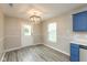 Sunlit dining area features modern lighting fixture, gray flooring, and access to the backyard at 671 Greenway St, Greenwood, IN 46143