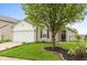 Charming single-Gathering home with a well-manicured lawn and a mature shade tree in the front yard at 671 Greenway St, Greenwood, IN 46143