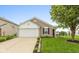 Inviting single-story home features a well-kept lawn, attached garage and neutral exterior paint at 671 Greenway St, Greenwood, IN 46143