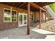 Covered back patio with brickwork, French doors, and a cozy American flag accent at 719 E New Rd, Greenfield, IN 46140