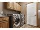 Bright laundry room with cabinets, granite counters, and stainless steel washer and dryer at 719 E New Rd, Greenfield, IN 46140