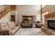 Comfortable living room features a fireplace, staircase, and a view into the kitchen with a breakfast bar at 719 E New Rd, Greenfield, IN 46140