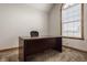 Bright office space featuring a large window and a wood desk with an office chair at 719 E New Rd, Greenfield, IN 46140