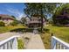 View of the back of the home with brick facade and a deck overlooking a spacious lawn at 719 E New Rd, Greenfield, IN 46140
