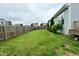 Large fenced backyard with green grass, mature trees, and a view of neighboring homes at 7515 Brattle Dr, Indianapolis, IN 46113