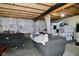 Unfinished basement featuring two black sofas and visible beams at 7515 Brattle Dr, Indianapolis, IN 46113