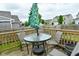 Wooden deck with round glass table, umbrella, and seating offers an inviting outdoor space at 7515 Brattle Dr, Indianapolis, IN 46113