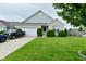 Charming single-story home with a well-maintained lawn, blue car and truck in driveway, and attractive landscaping at 7515 Brattle Dr, Indianapolis, IN 46113