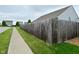 A sidewalk shows the neighborhood, with green grass and a wooden fence adjacent to a beige two-story home at 7515 Brattle Dr, Indianapolis, IN 46113