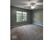 Cozy bedroom with neutral carpet, large window, and ceiling fan at 7548 Briarstone Dr, Indianapolis, IN 46227