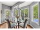 Bright breakfast nook featuring a round glass table, gray chairs, and scenic views through multiple windows at 790 Foxboro Dr, Avon, IN 46123